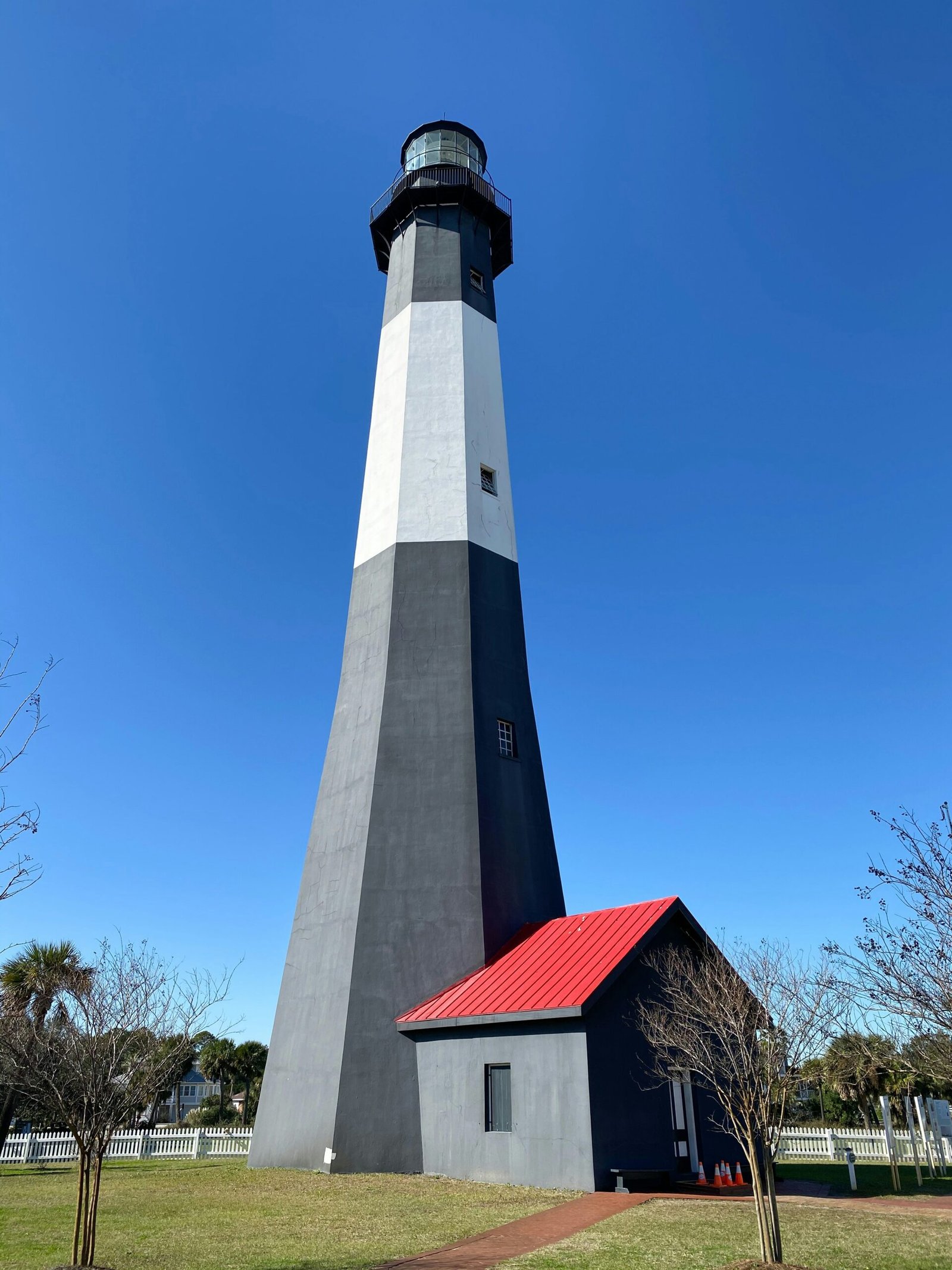 white and black concrete lighthouse under blue sky during daytime